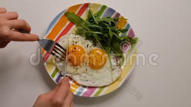 盘子里有两个煎蛋。 把盘子和煎蛋放在木桌上。 用煎蛋把<strong>白瓷</strong>盘合上